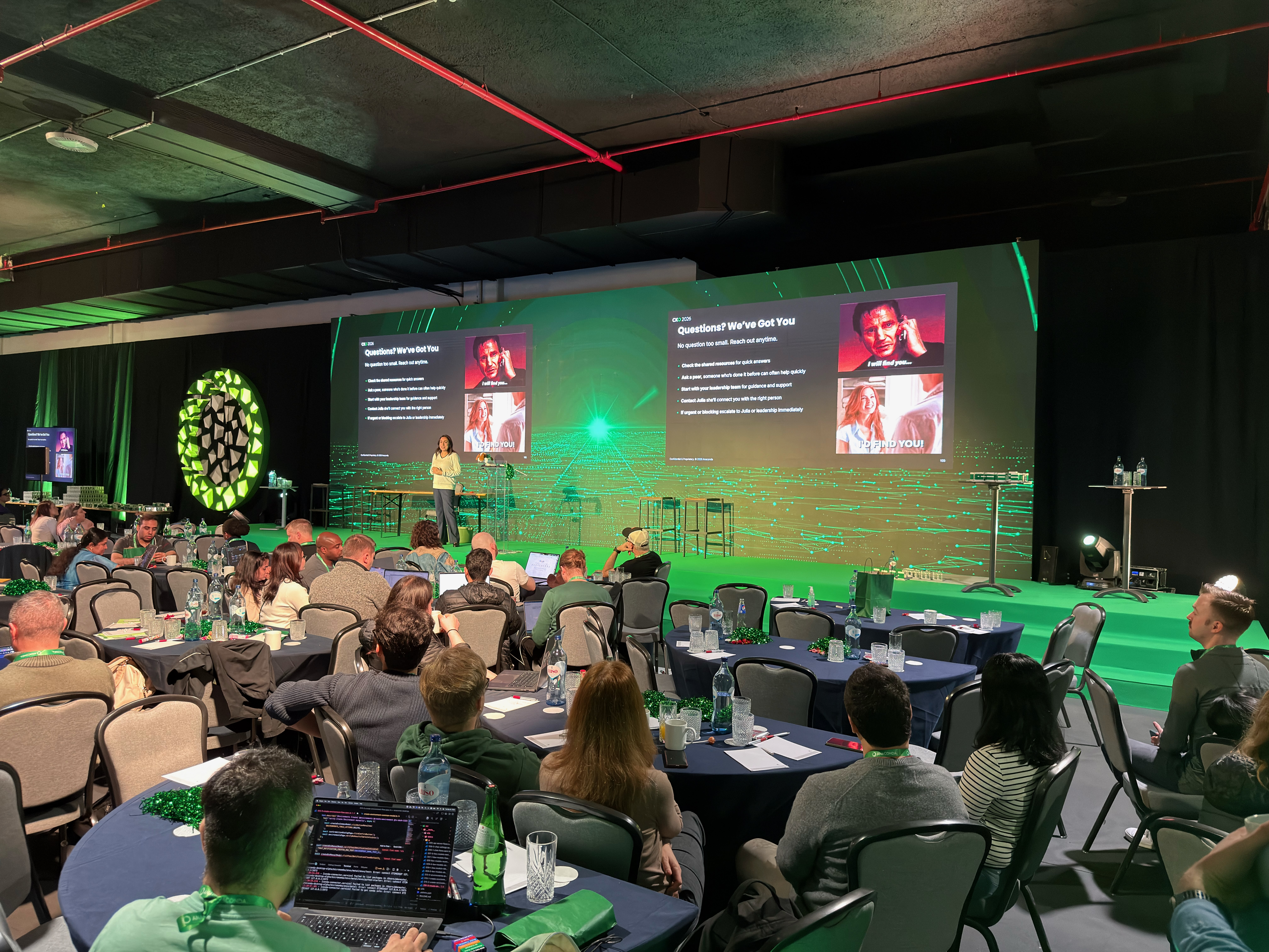 The CKO 2026 venue — round tables, green-lit stage, and the whole company together in Portugal